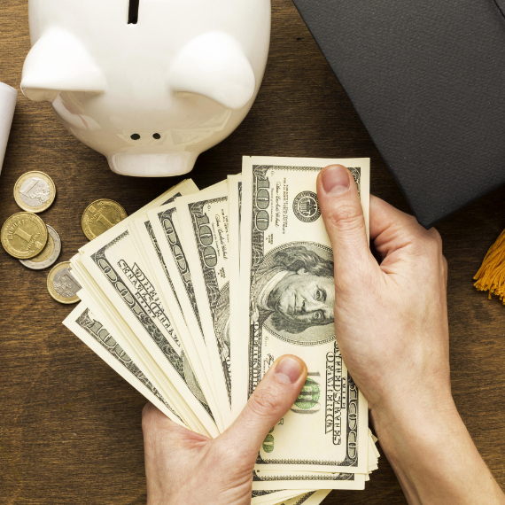 flat-lay-piggy-bank-with-academic cap-banknotes