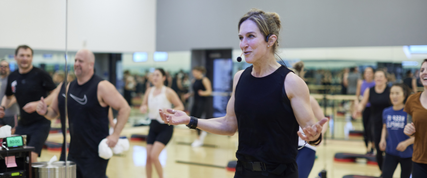 Woman instructor leading a group exercise class